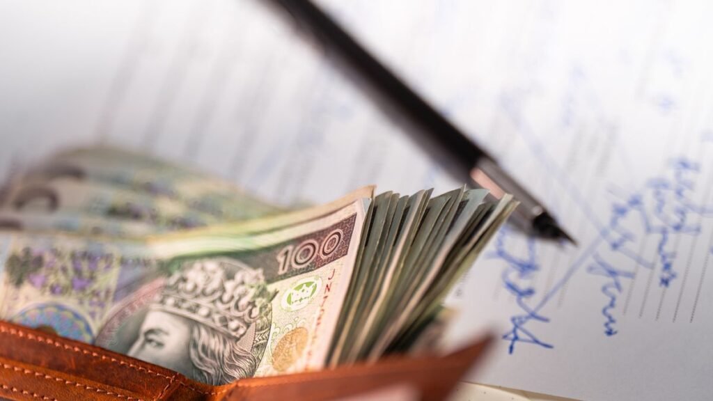 Cash next to a signed contract and pen