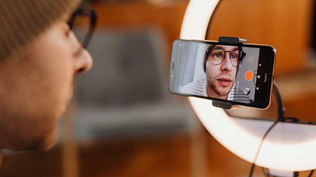 Creator recording a video on a smartphone with a ring light