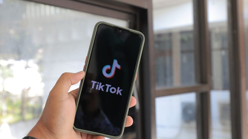 Hand holding a smartphone with the TikTok app open