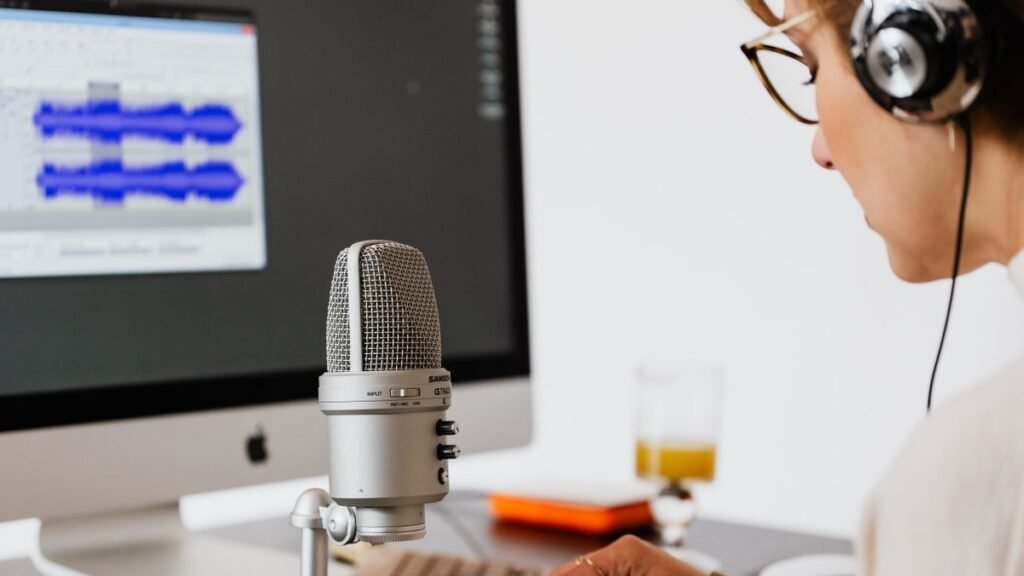 Creator recording clean voice audio with a microphone and headphones at a home desk