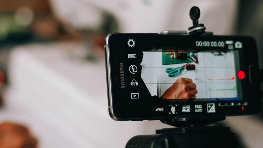 Smartphone on a tripod filming a creator at work